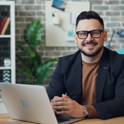 a man sitting at a table with a laptop