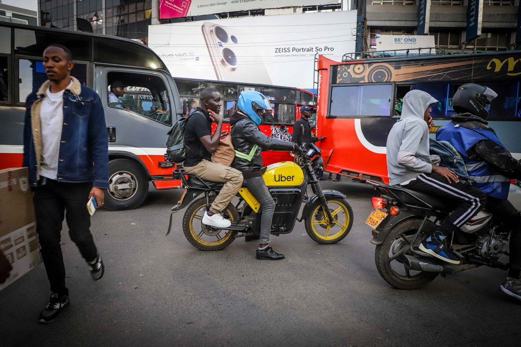 An electric Boda carries a passenger through the streets of Nairobi